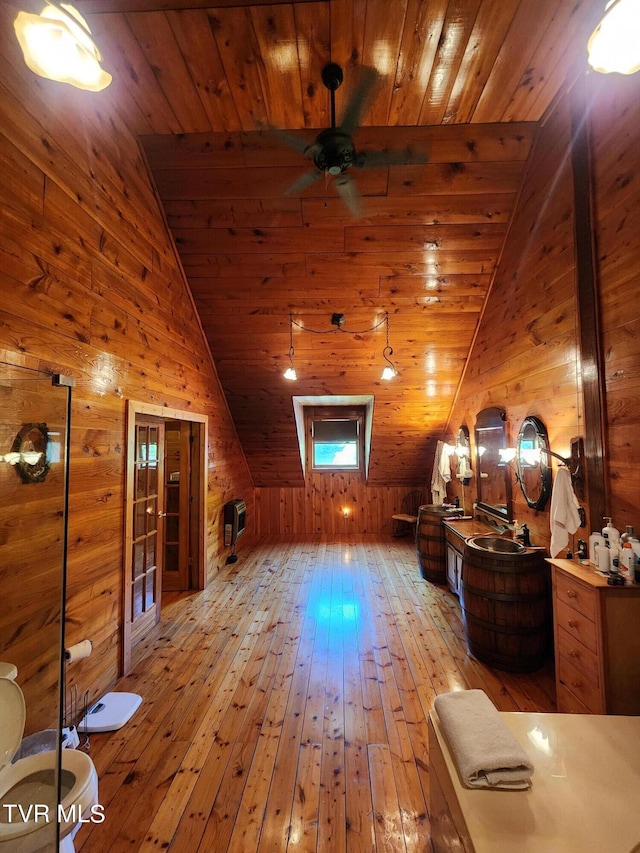 additional living space featuring lofted ceiling, wood ceiling, light hardwood / wood-style floors, and wood walls