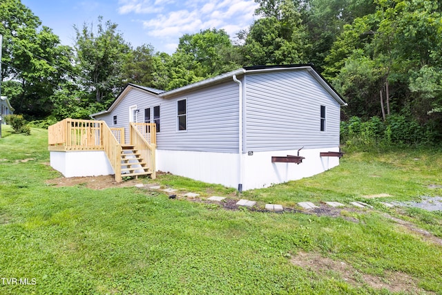 view of side of property featuring a wooden deck and a yard