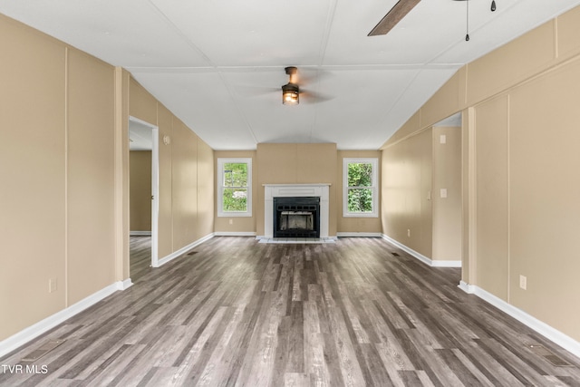 unfurnished living room with dark hardwood / wood-style floors, ceiling fan, and vaulted ceiling