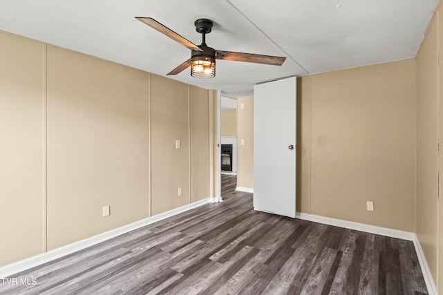 spare room featuring dark wood-type flooring and ceiling fan