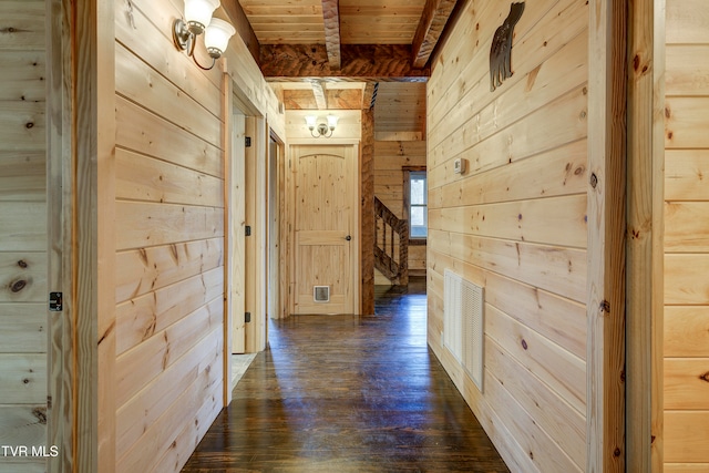 hallway featuring wooden ceiling, beam ceiling, wooden walls, and dark wood-type flooring