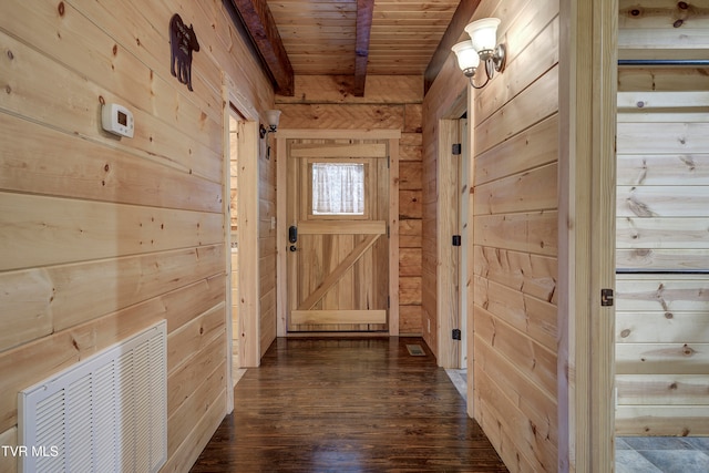 doorway to outside with wooden ceiling, beamed ceiling, wooden walls, and dark hardwood / wood-style floors