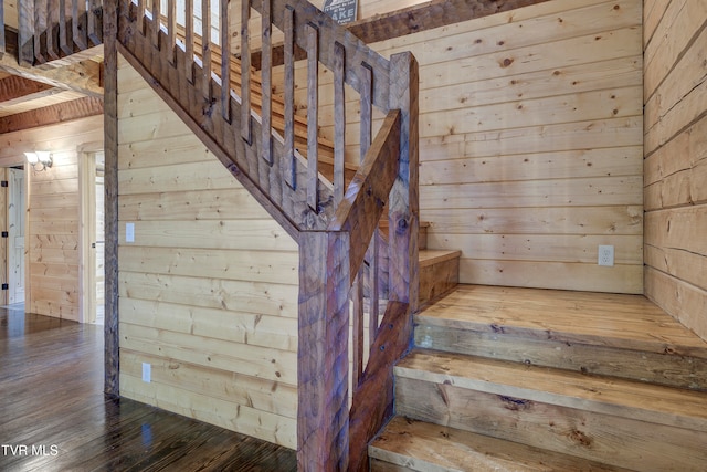 stairway featuring wood walls and wood-type flooring