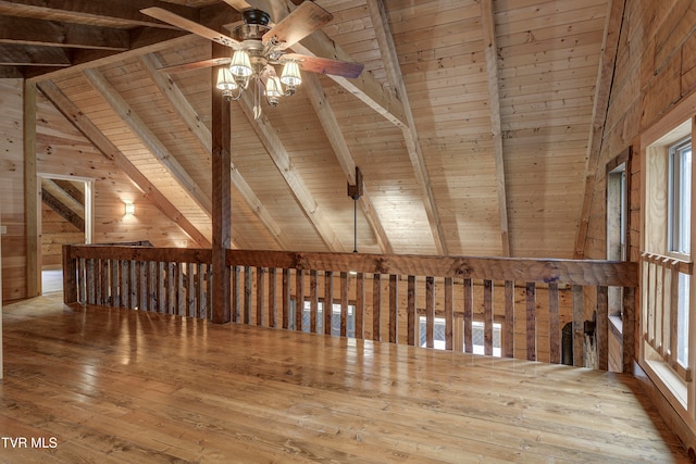 additional living space featuring wood ceiling, beamed ceiling, wooden walls, hardwood / wood-style floors, and ceiling fan