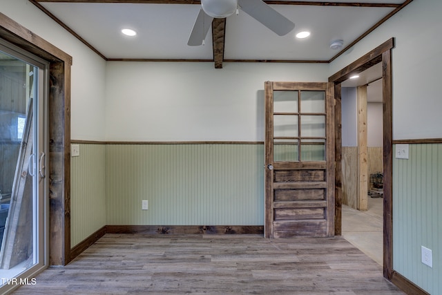 empty room with ceiling fan, crown molding, and light hardwood / wood-style flooring