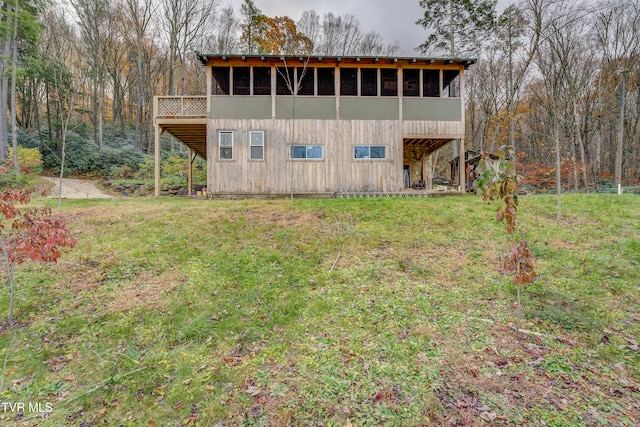 back of house with a yard and a sunroom