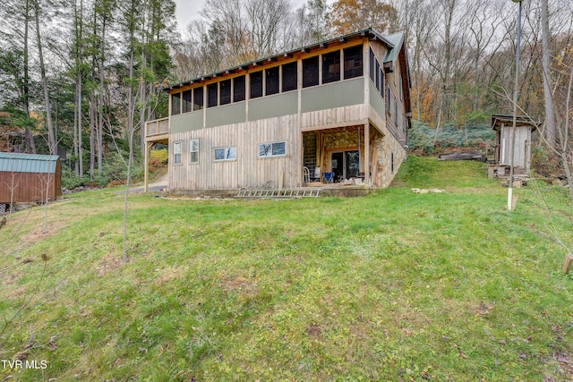 rear view of house featuring a storage shed and a yard