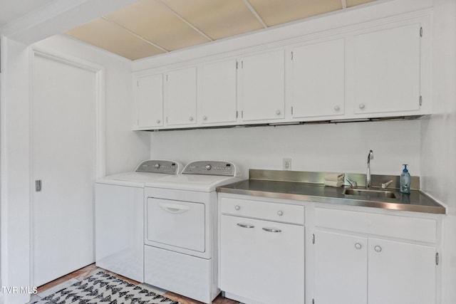 laundry room featuring cabinets, sink, light hardwood / wood-style floors, and washing machine and dryer