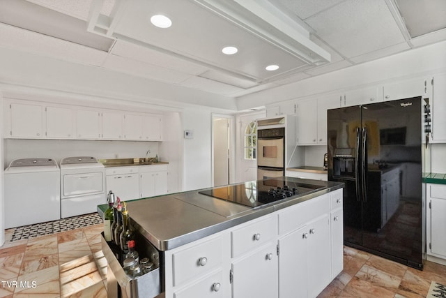 kitchen with washer and dryer, white cabinetry, black appliances, and light tile flooring