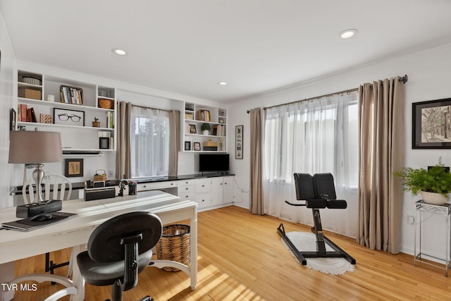 home office featuring light hardwood / wood-style floors, ornamental molding, and built in features