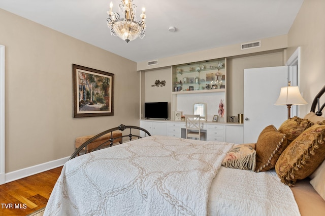 bedroom featuring wood-type flooring and an inviting chandelier