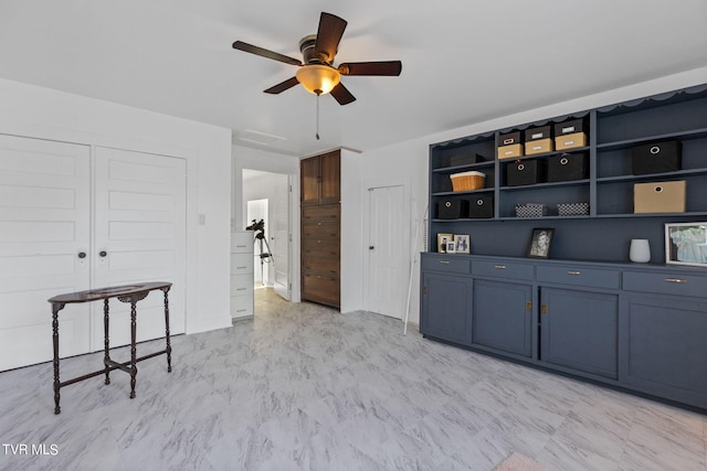 interior space featuring blue cabinets, ceiling fan, and light tile flooring