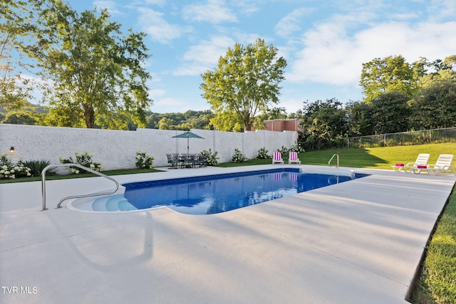 view of swimming pool featuring a patio area and a yard