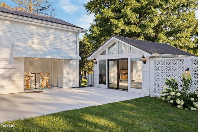 rear view of property with a patio and a yard