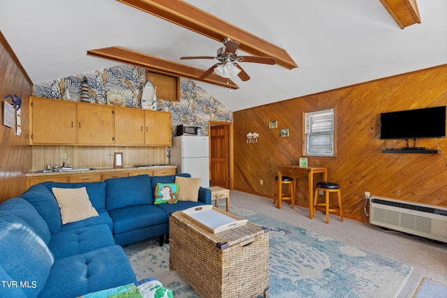 carpeted living room with wood walls, sink, vaulted ceiling with beams, and ceiling fan