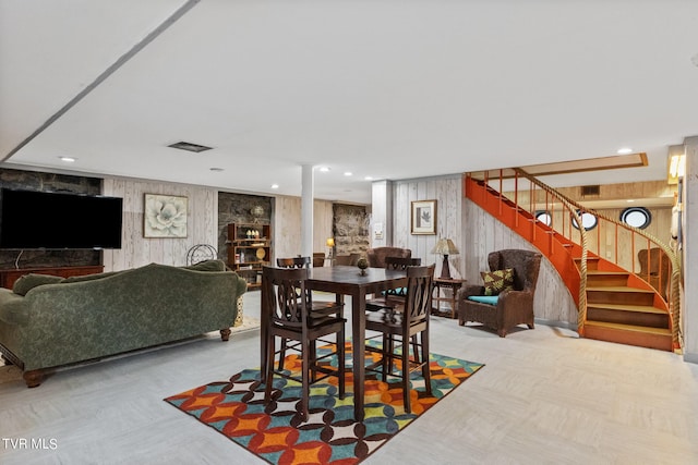 dining area featuring wooden walls and a fireplace