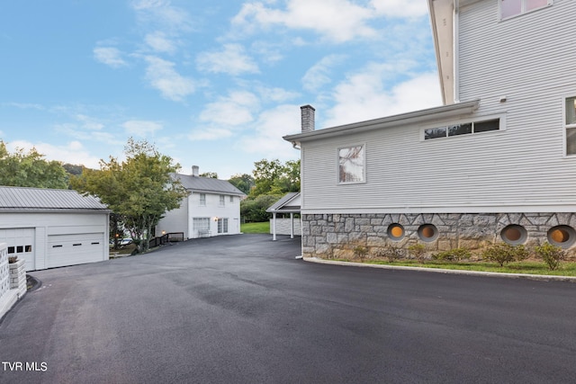 view of property exterior with a garage and an outdoor structure