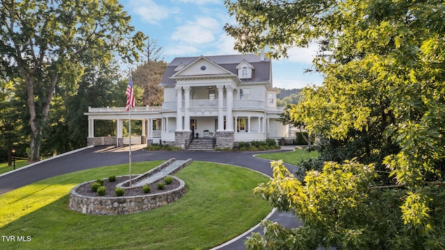 view of front of property with a front lawn, a carport, a balcony, and a porch