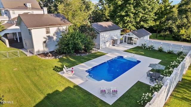 view of pool with a patio, a yard, and an outdoor structure