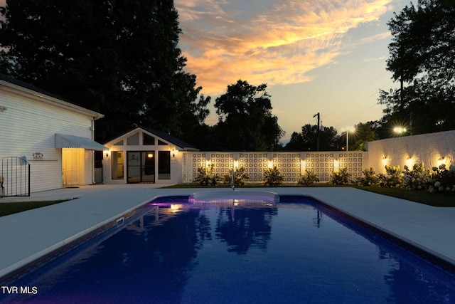 pool at dusk with a patio