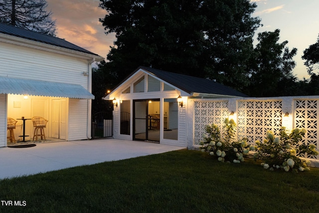 view of front of house with a patio and a lawn