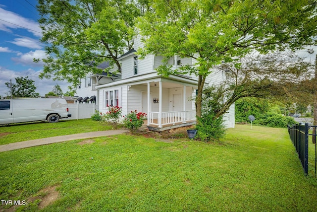 view of front of house with a front yard, fence, and covered porch