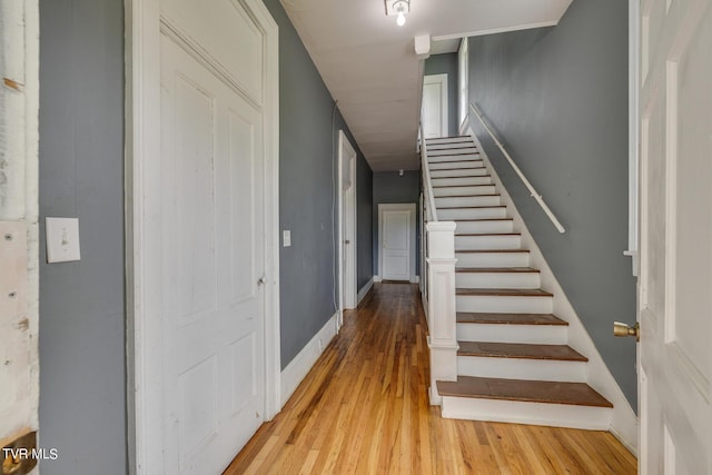 staircase with baseboards and wood finished floors