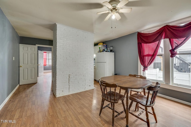 dining room with baseboards, a ceiling fan, and wood finished floors