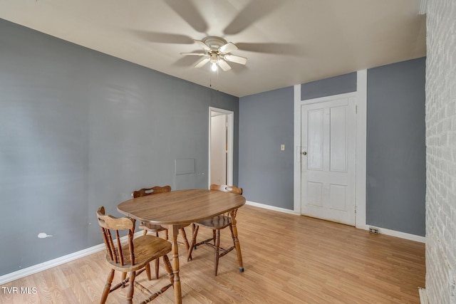 dining area with light wood-style floors, baseboards, and a ceiling fan