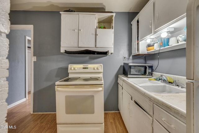 kitchen featuring open shelves, a sink, stainless steel microwave, white electric range oven, and light wood-style flooring