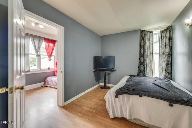 bedroom with light wood-style floors and baseboards