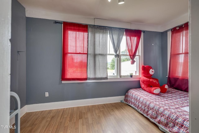 bedroom with baseboards and wood finished floors