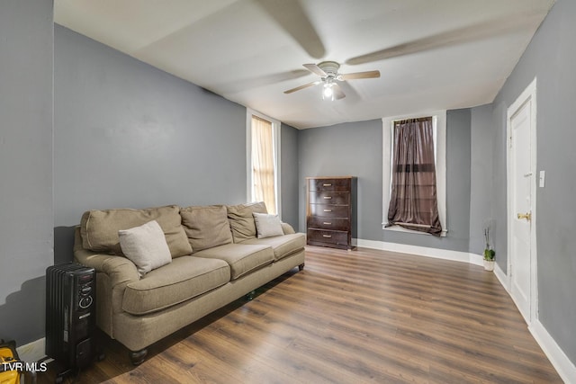 living room with baseboards, a ceiling fan, and wood finished floors