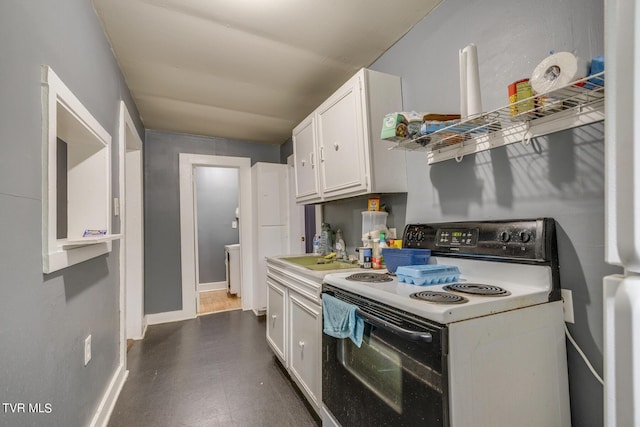kitchen featuring light countertops, white cabinets, white electric range, a sink, and dark floors