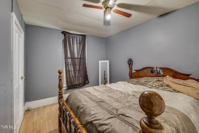 bedroom with ceiling fan, baseboards, and wood finished floors