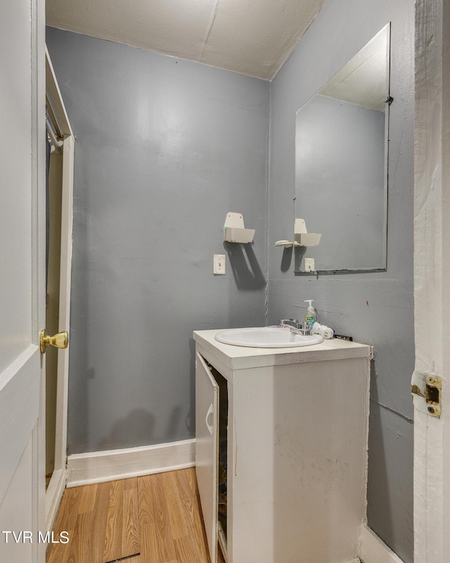 bathroom with vanity, baseboards, and wood finished floors