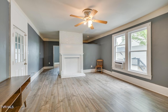 unfurnished living room with light wood finished floors, baseboards, and a ceiling fan