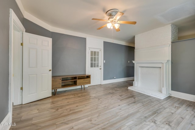 unfurnished living room with light wood-style flooring, baseboards, and a ceiling fan