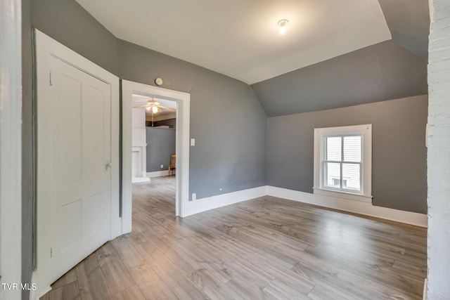 bonus room featuring wood finished floors, baseboards, a ceiling fan, and lofted ceiling
