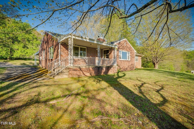 view of front facade with a front yard and covered porch