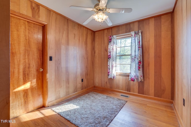 unfurnished room featuring ornamental molding, ceiling fan, and light wood-type flooring