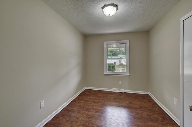 unfurnished room featuring dark hardwood / wood-style floors and a textured ceiling