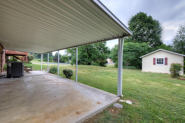 view of yard featuring cooling unit, an outbuilding, and a patio