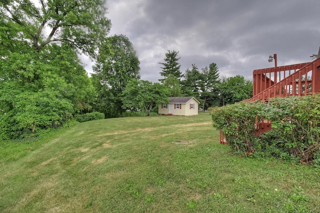 view of yard featuring a wooden deck and an outdoor structure