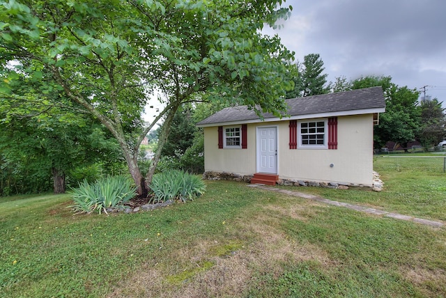 view of front of home featuring an outdoor structure and a front lawn