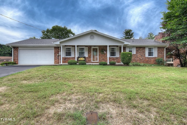 ranch-style house with a garage, covered porch, and a front lawn