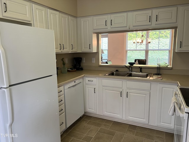 kitchen featuring white cabinets, white appliances, a chandelier, and sink