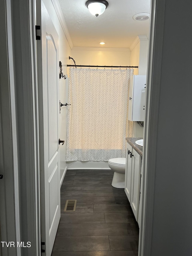 bathroom with crown molding, wood-type flooring, vanity, and toilet