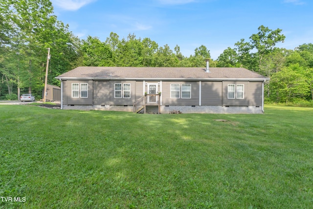 rear view of house with a shingled roof, a yard, and crawl space