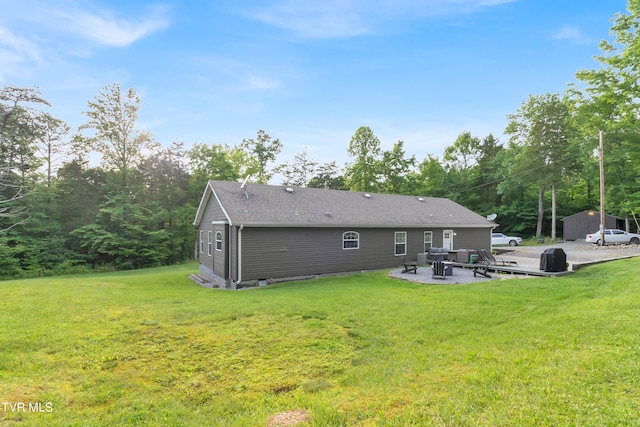 rear view of property featuring a patio, a shed, and a lawn